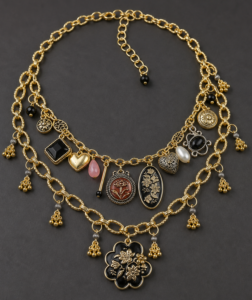 Gold necklace with various charms on a dark background