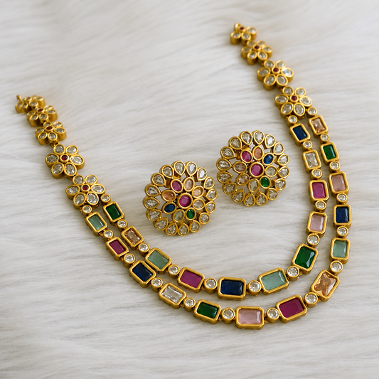 Gold necklace with colorful gemstones on a white background