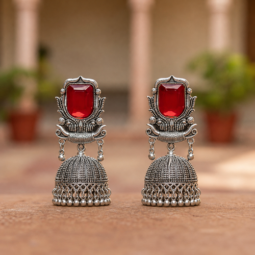 Pair of silver earrings with red gemstones.
