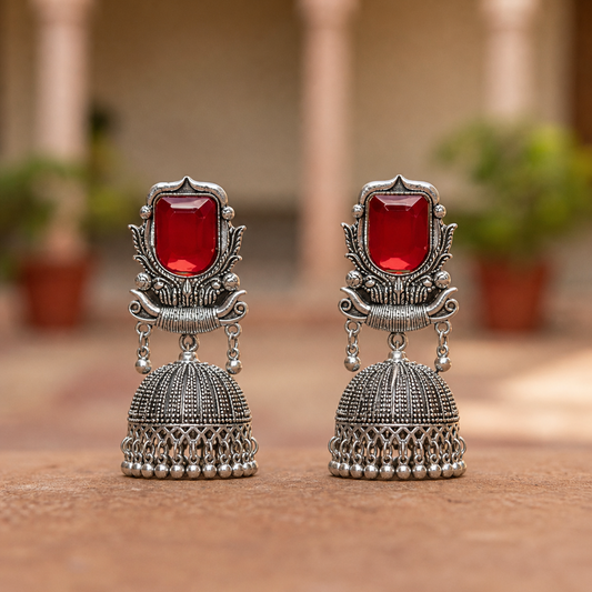 Pair of silver earrings with red gemstones.
