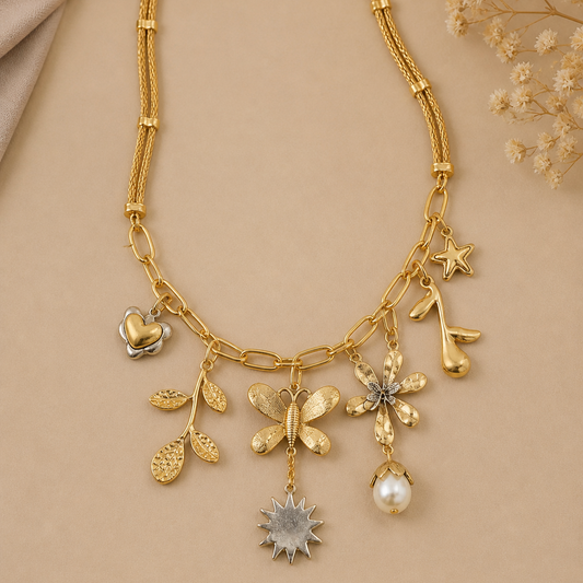 Gold necklace with floral and star-shaped charms on a beige background