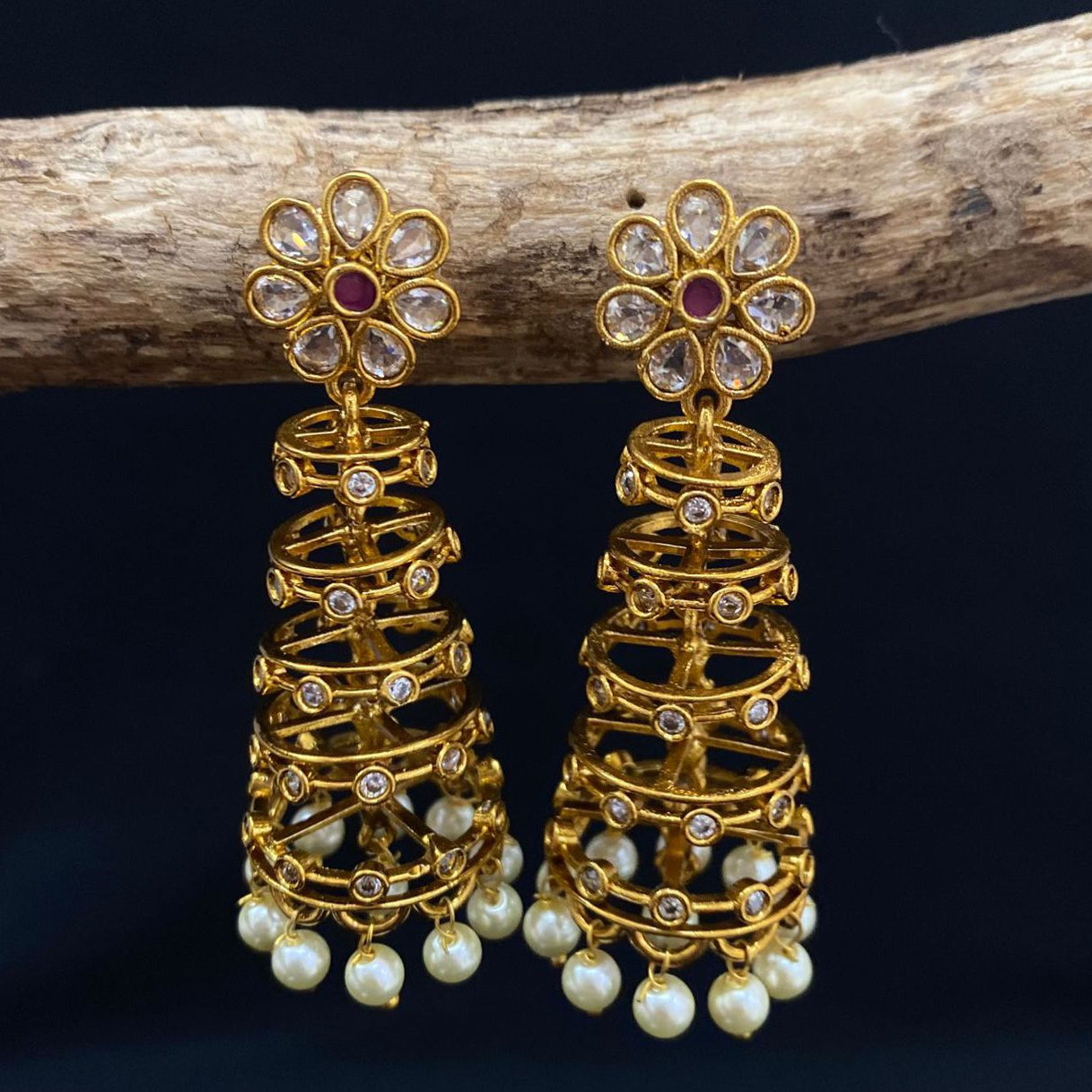 Gold earrings with floral design and pearl drops.
